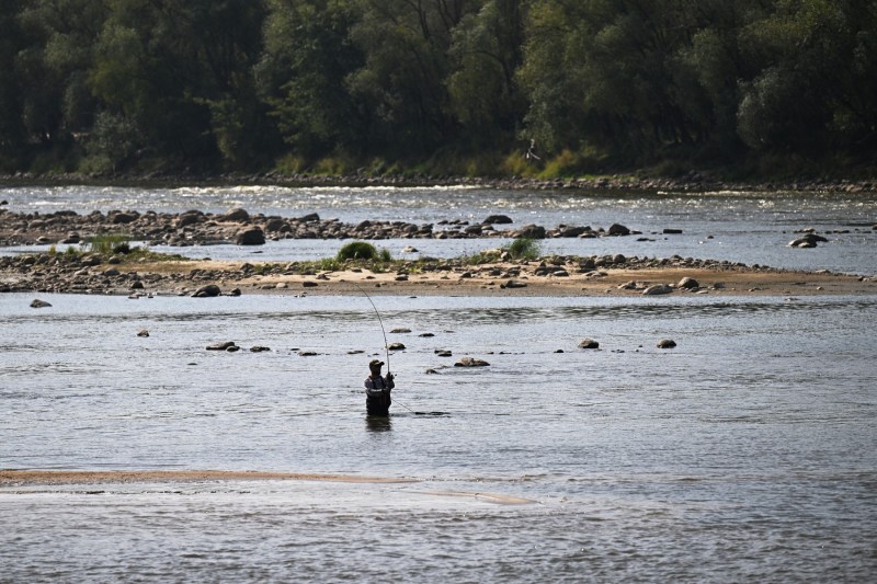 Un bărbat pescuiește în fluviul Vistula din Varșovia, afectat de secetă, pe 6 septembrie 2024. Potrivit hidrologilor, nivelul apei a atins un minim istoric de 25 de centimetri din cauza lipsei de precipitații semnificative și a temperaturilor ridicate. Foto: Sergei GAPON / AFP / Profimedia